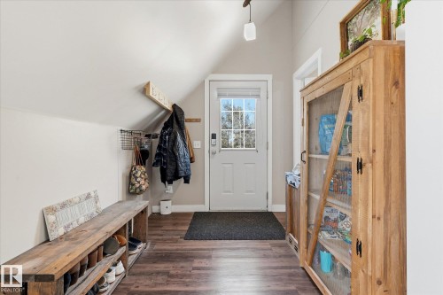 Vaulted ceiling entryway with wood-finish flooring, white paneled door with glass insert, and built-in wood shelving - #45 53122 Rge Road 14, Rural Parkland County, AB 