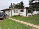 Exterior featuring light-colored siding with brown trim, covered front entry, bay window, and a concrete paver walkway - 4626 51 Avenue, Willingdon, AB 