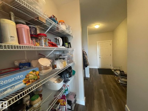 Wire shelving system providing vertical storage, complemented by wood-finish flooring - 7939 Erasmus Crescent Nw, Edmonton, AB 