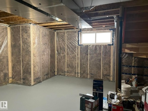 Unfinished basement space with a concrete floor, framed walls, visible insulation, and a double-hung window - 7939 Erasmus Crescent Nw, Edmonton, AB 