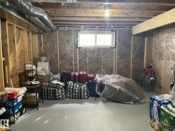 Unfinished lower level with wood framing, exposed ductwork, and a single window - 