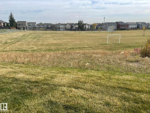 Expansive green space featuring large grassy areas and distant residential structures - 7939 Erasmus Crescent Nw, Edmonton, AB 