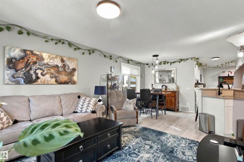 Recessed lighting with modern fixtures, wood-finish flooring, and a kitchen pass-through with a breakfast bar - 38 Red Tail Way, St. Albert, AB 