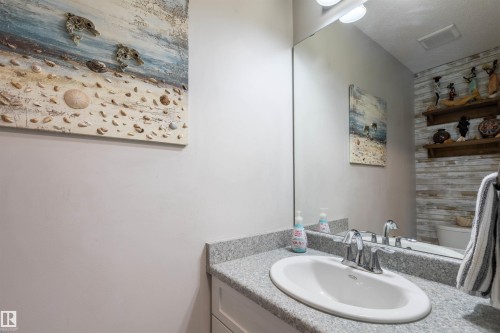 White oval sink with chrome faucet, light grey speckled countertop, white cabinetry - 38 Red Tail Way, St. Albert, AB 