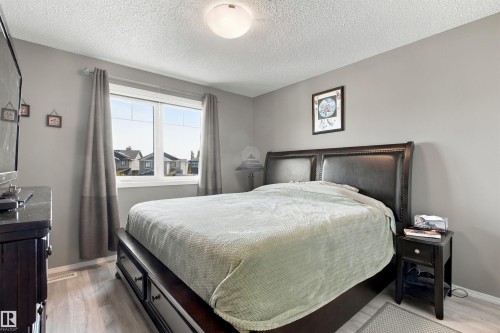 Spacious room featuring light gray walls, a large window, light wood-finish flooring, and a flush mount ceiling light - 38 Red Tail Way, St. Albert, AB 