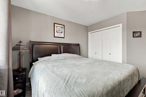 Neutral wall paint, textured ceiling, double bi-fold closet doors, and wood-finish flooring - 38 Red Tail Way, St. Albert, AB 