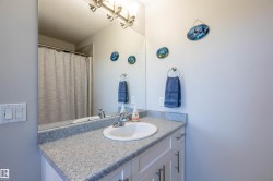 Vanity with integrated sink, speckled countertop, and white cabinetry - 