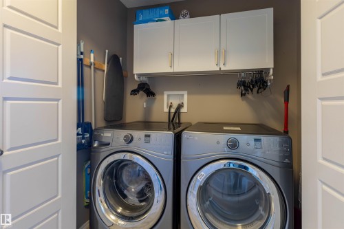 Laundry area with built-in cabinetry, overhead hanging rod, and two-panel interior doors - 38 Red Tail Way, St. Albert, AB 