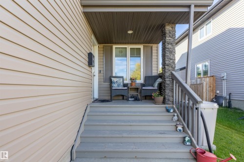 Front porch featuring a stone-clad support column and wood railings - 38 Red Tail Way, St. Albert, AB 