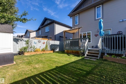 Expansive backyard featuring a wood deck with steps, a wood pergola, a wood-fenced perimeter, and a storage shed - 38 Red Tail Way, St. Albert, AB 