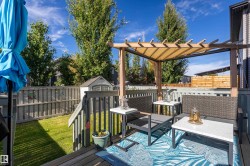 Wood deck with a pergola featuring a retractable fabric cover, wood privacy fence, and a storage shed - 