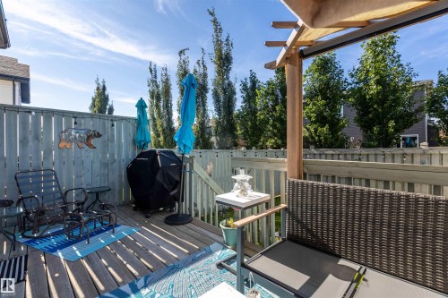 Wood-finish deck with a privacy fence, wood pergola, and built-in railing - 38 Red Tail Way, St. Albert, AB 