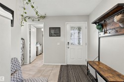 Entryway featuring a white paneled door with decorative glass, light grey wall paint, and tile flooring - 