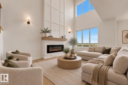 Soaring ceilings, a fireplace with a wood mantle and stone surround, and expansive windows offering abundant light - 
