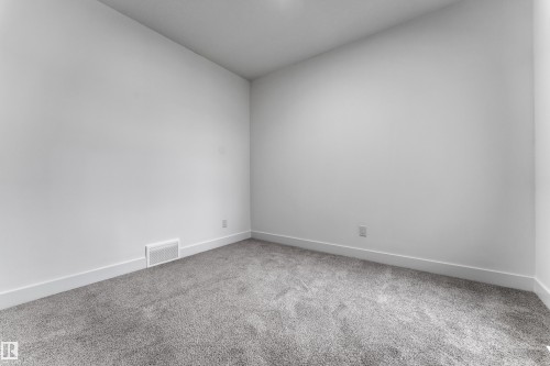 Neutral wall finishes and gray carpet - 794 Bank Drive, Leduc, AB 