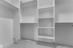 Integrated closet system with multiple shelving units, hanging rods, and light-toned tile flooring - 