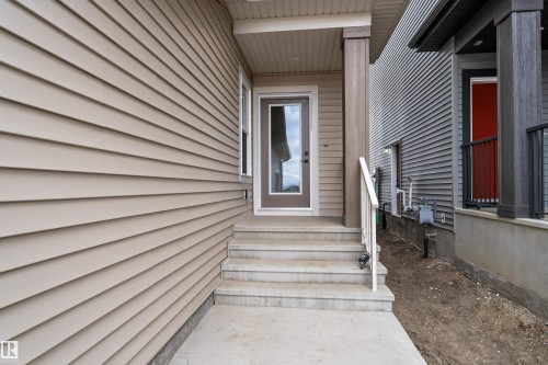 Entry with concrete steps, a full-lite door, and a covered porch - 794 Bank Drive, Leduc, AB 