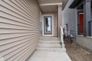 Entry with concrete steps, a full-lite door, and a covered porch - 794 Bank Drive, Leduc, AB 