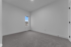 Neutral gray carpeting with white trim, single window, and white interior door with black hardware - 