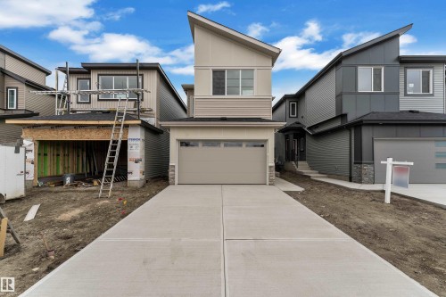 Contemporary exterior with multi-toned siding, stone accents, and an attached garage - 794 Bank Drive, Leduc, AB 