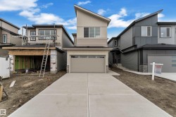 Contemporary exterior with multi-toned siding, stone accents, and an attached garage - 