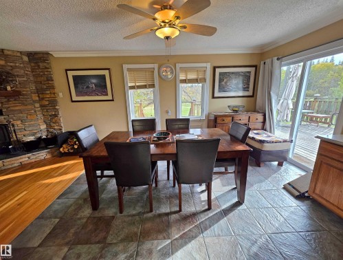 Dining Area with ceramic tile flooring, ceiling fan with integrated lighting, and sliding glass door leading to a wood deck - 9131 Township Road 554, Rural St. Paul County, AB 