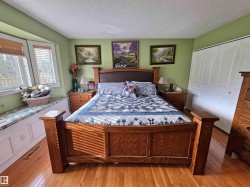 Hardwood flooring throughout, bay window with integrated window seat, dual bi-fold closet doors, and light green wall finish - 