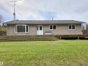 Ranch-style exterior with neutral siding, a bay window, and a full-width wooden deck - 9131 Township Road 554, Rural St. Paul County, AB 