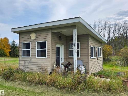 Siding exterior with multiple windows, covered entry, and a sloped roof - 9131 Township Road 554, Rural St. Paul County, AB 