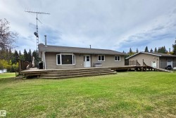 Exterior featuring neutral-toned siding, a wood deck, & a bay window - 