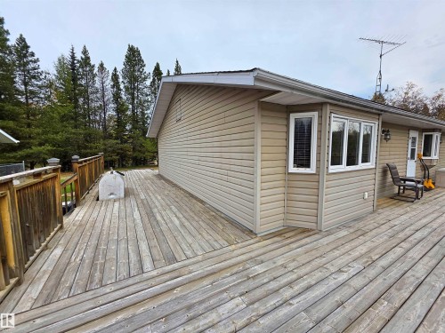 Expansive wood deck with a perimeter railing - 9131 Township Road 554, Rural St. Paul County, AB 