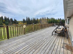 Expansive wood deck with a full-height wood railing, offering broad landscape views, facing south - 