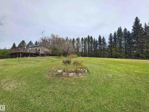 Expansive green lawn with a rock-lined garden bed - 9131 Township Road 554, Rural St. Paul County, AB 