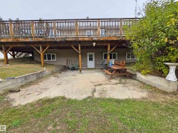 Expansive wood-finish deck with railing, ground-level entry, and multiple windows - 