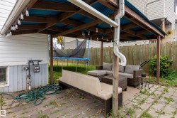 Covered patio with a wood-framed structure and corrugated roof - 