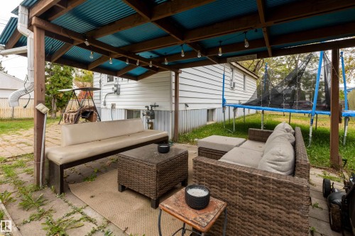Covered patio area featuring a corrugated metal roof and string lighting - 12707 73 Street Nw, Edmonton, AB 