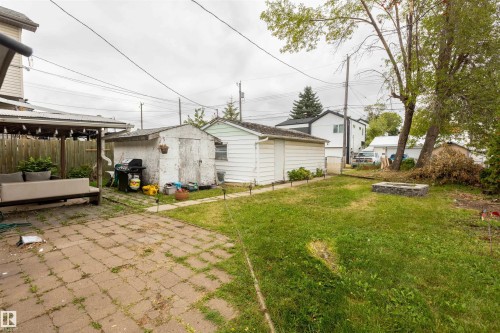 Spacious backyard with mature landscaping and established lawn, complemented by a detached shed structure and paver patio area - 12707 73 Street Nw, Edmonton, AB 