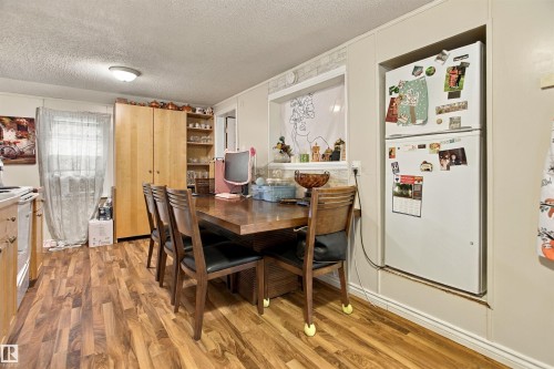 Wood-finish flooring throughout, with a built-in refrigerator alcove and a window with a tiled sill - 12707 73 Street Nw, Edmonton, AB 