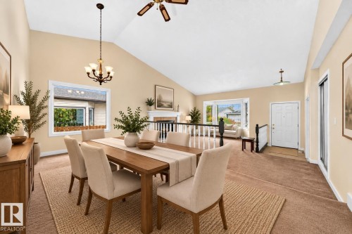 Vaulted ceilings, a chandelier, and a wood-finish dining table define this space - 7307 152C Avenue Nw, Edmonton, AB 