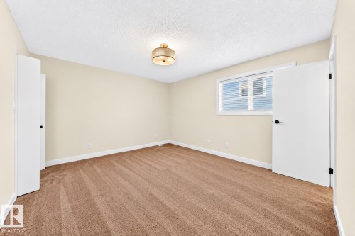 Neutral-toned walls complement the textured carpet flooring - 7307 152C Avenue Nw, Edmonton, AB 