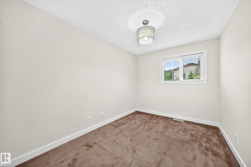 Light-colored walls, brown carpeting, and a window with horizontal blinds - 7307 152C Avenue Nw, Edmonton, AB 