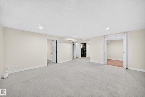 Spacious interior with neutral wall paint, recessed lighting, and light-colored carpeting - 7307 152C Avenue Nw, Edmonton, AB 