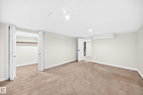 Plush carpet flooring, white walls, recessed ceiling lighting, built-in closet with shelving, and white interior doors - 7307 152C Avenue Nw, Edmonton, AB 
