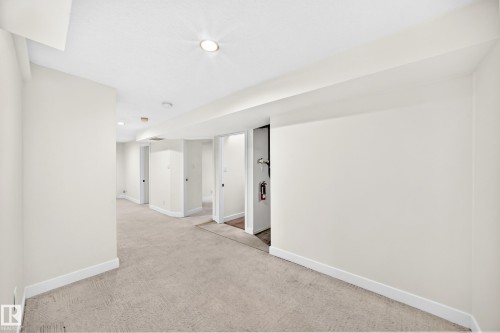 Recessed lighting illuminating a spacious room with light-colored carpeting - 7307 152C Avenue Nw, Edmonton, AB 