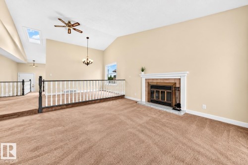 Vaulted ceiling with skylight, ceiling fan, and chandelier - 7307 152C Avenue Nw, Edmonton, AB 