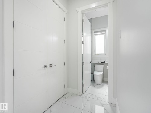Two white paneled doors with horizontal detailing, polished chrome hardware, and white trim - 120 38 Street Sw, Edmonton, AB 