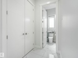 Two white paneled doors with horizontal detailing, polished chrome hardware, and white trim - 