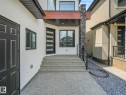 White stucco exterior with a prominent stone-clad pillar - 120 38 Street Sw, Edmonton, AB 