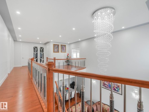 Wood-finish flooring with a modern wood and metal railing - 120 38 Street Sw, Edmonton, AB 