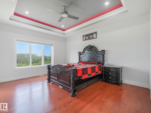 Wood-finish flooring, recessed lighting, ceiling fan, tray ceiling, and large window - 120 38 Street Sw, Edmonton, AB 